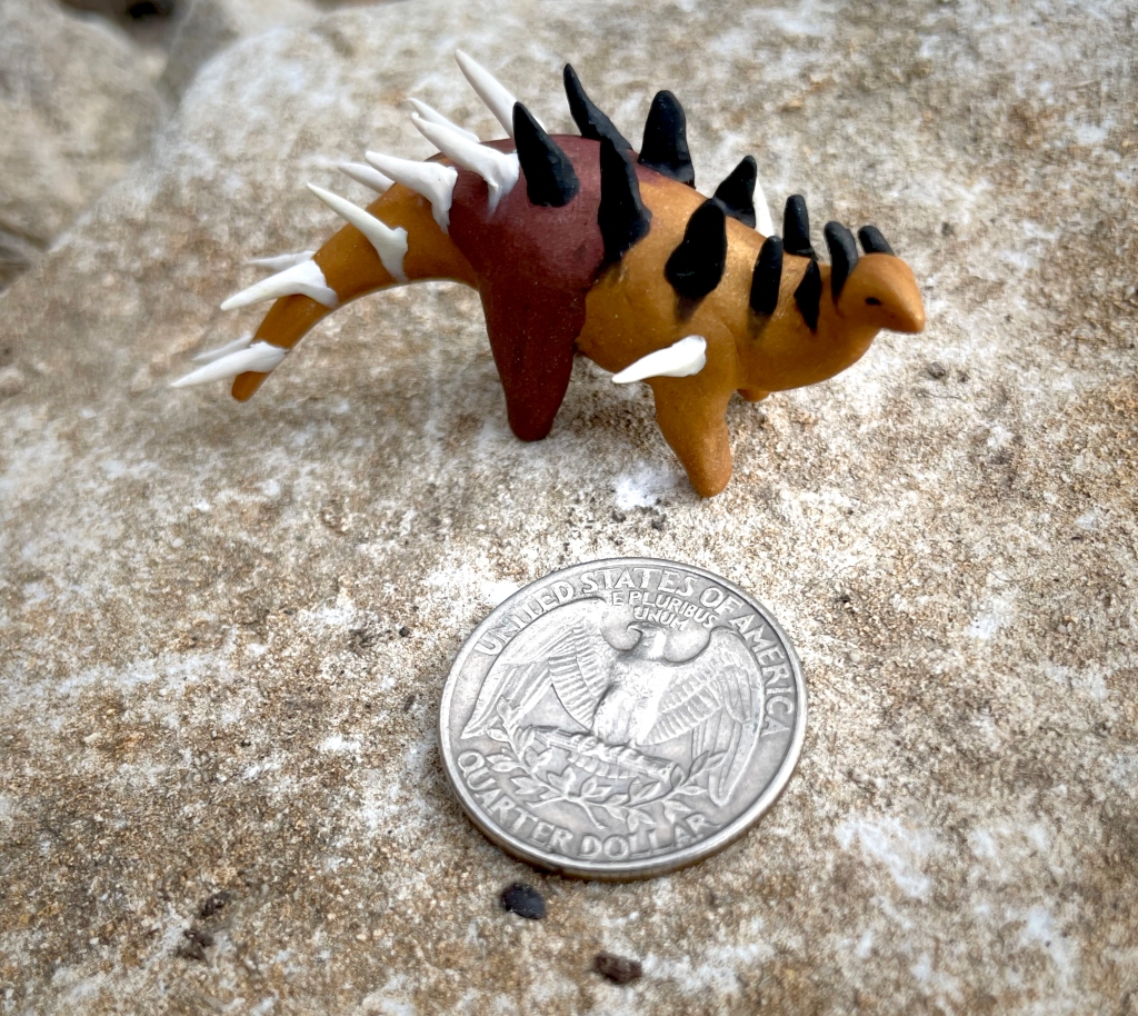 The cute Kentrosaurus is about the size of a quarter